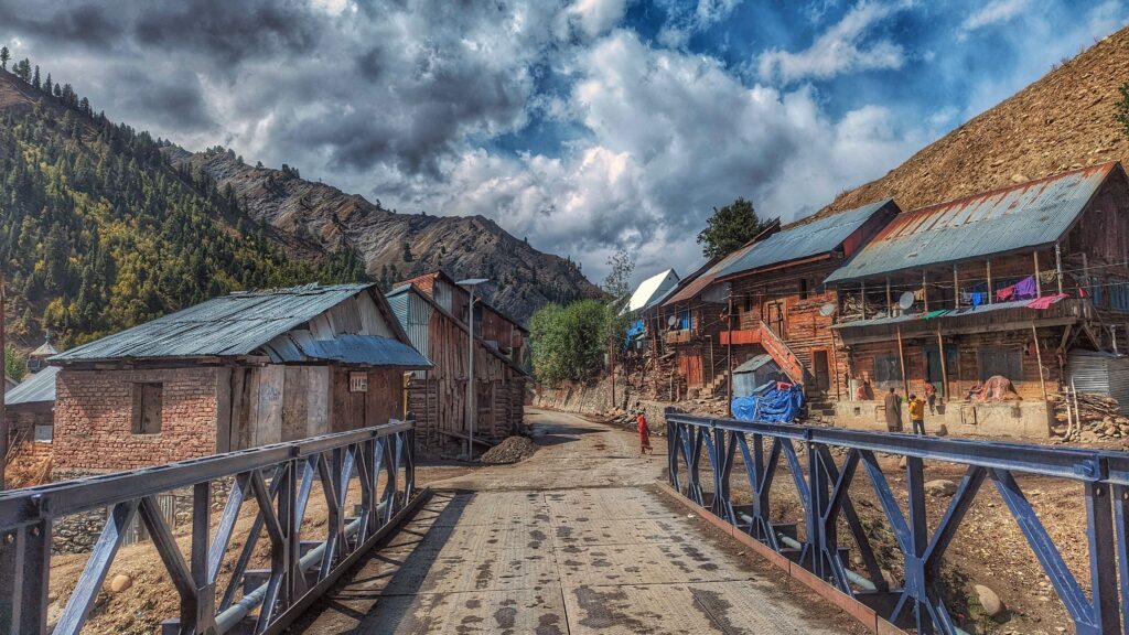Scenic view of Barnoi village in Tulail Valley, with scattered wooden homes.