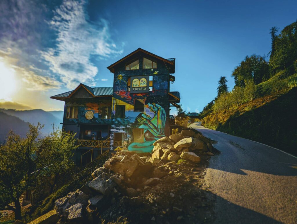 "Beautifully painted Stay in Shoja, Himachal Pradesh, surrounded by lush greenery and offering serene Himalayan views."