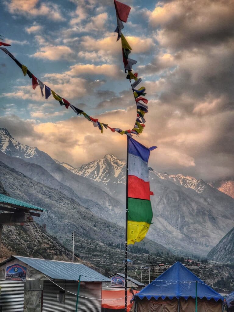 The serene village of Chitkul, nestled amidst the Himalayas, where calmness abounds, and the gentle rustling of colorful prayer flags adds a spiritual touch to the tranquil atmosphere.