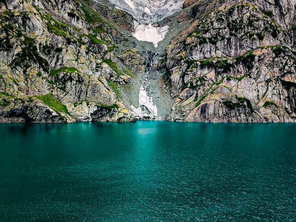 The stunning Gadsar Lake in Kashmir, with its deep blue waters surrounded by mountains.