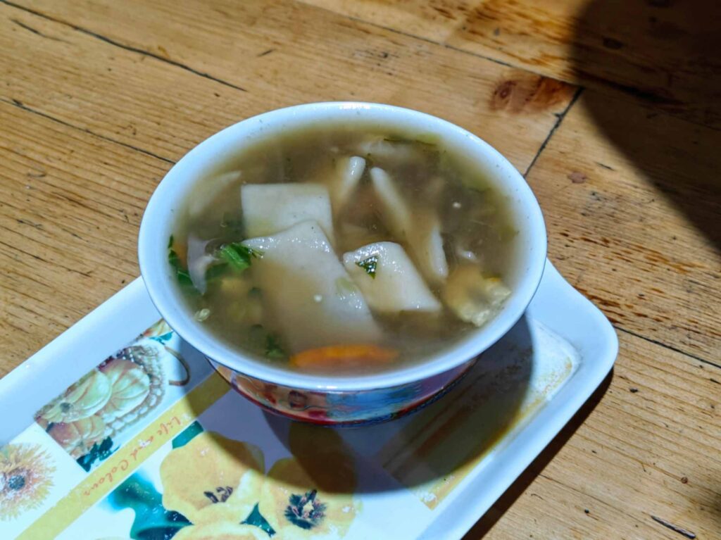 A bowl of warm and hearty Thenthuk, a traditional Tibetan hand made noodle soup, served at Khandroling Homestay in Lahaul Valley.