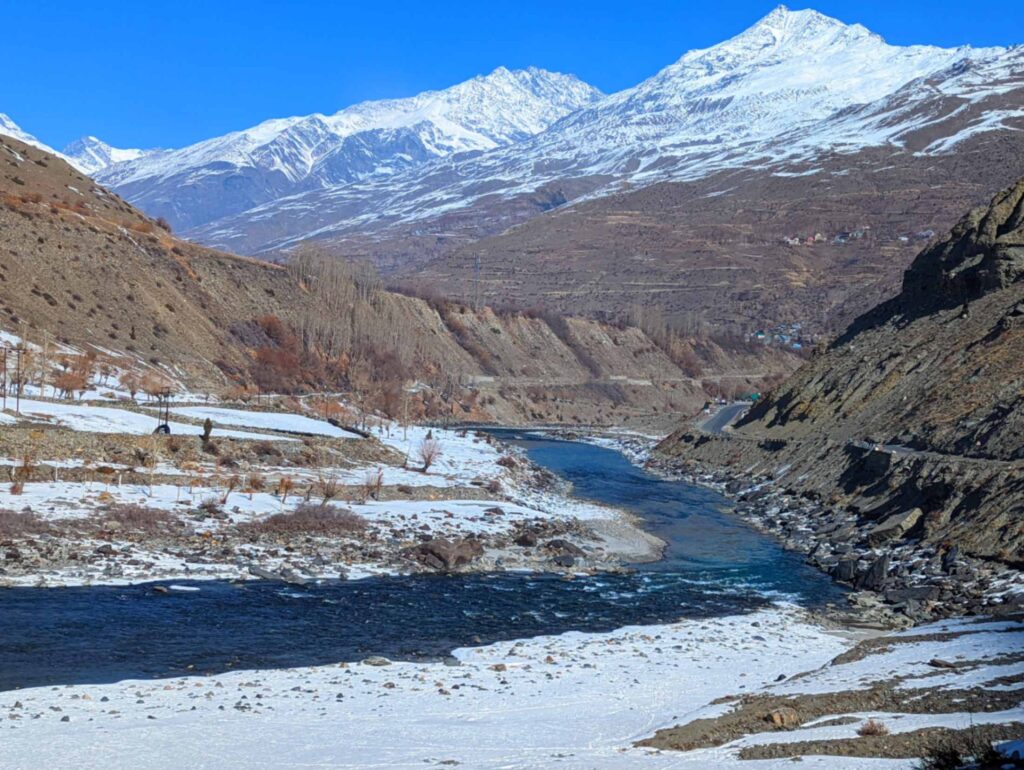 Scenic view of the Bhaga River flowing through Lahaul Valley, Himachal Pradesh, surrounded by rugged mountains and pristine natural beauty.