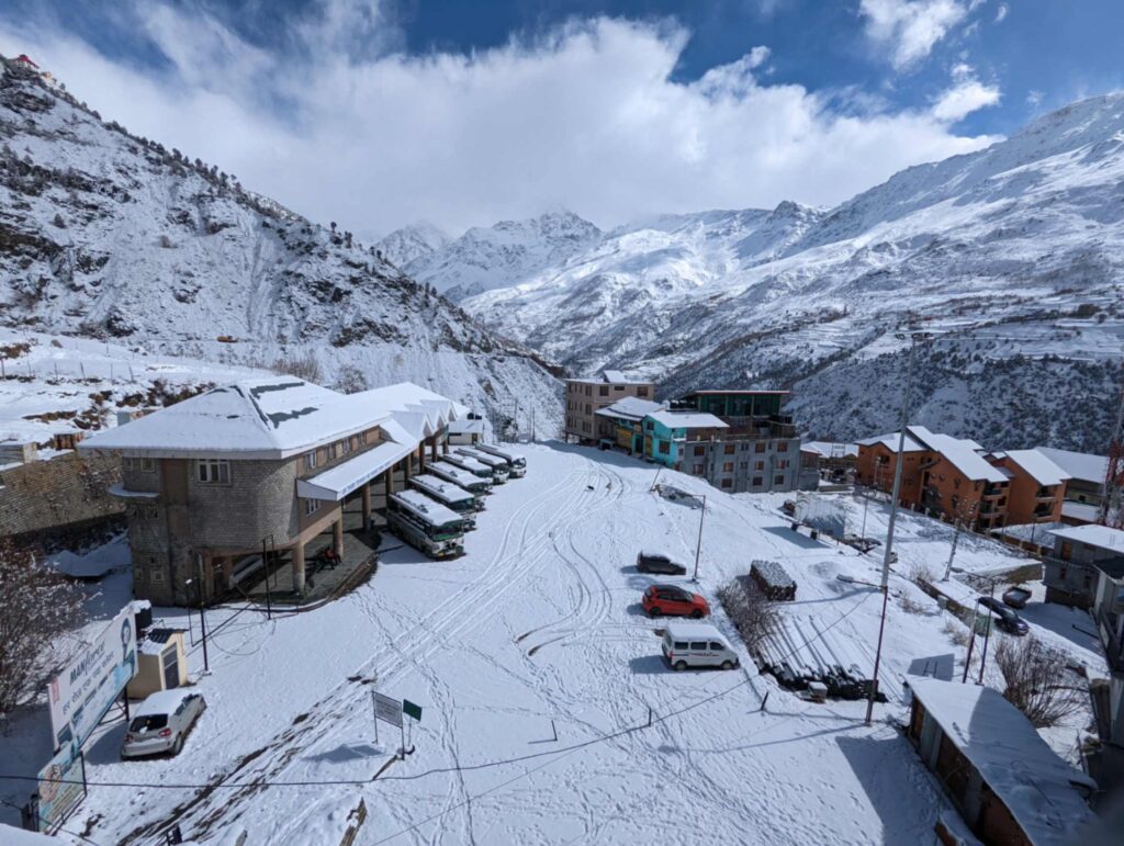 Snow-covered bus stand in Keylong, Lahaul Valley, Himachal Pradesh, surrounded by majestic Himalayan peaks and a serene winter landscape.