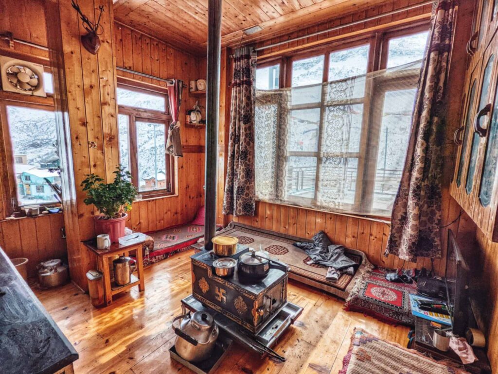 Ancient Himachali-style traditional kitchen in Khandroling Homestay, featuring rustic wooden interiors, traditional cooking utensils, and a cozy, warm ambiance.