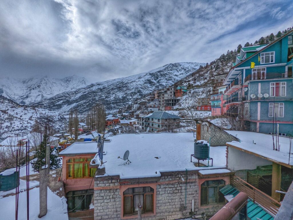 Snow-covered landscape in Keylong, Lahaul Valley, Himachal Pradesh, featuring majestic mountains, white-capped peaks, and a serene winter atmosphere.