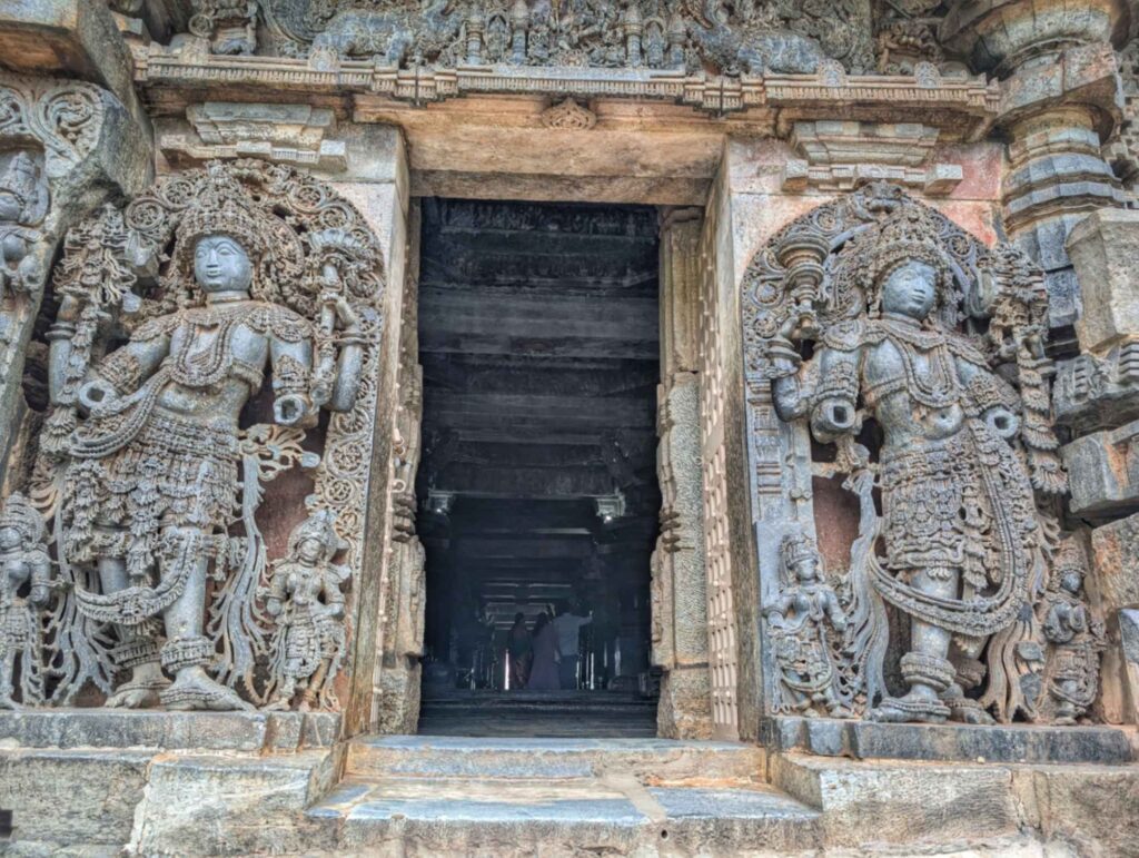 Guardian figure at the entrance of a Hoysala temple, featuring elaborate carvings, dynamic posture, and traditional iconography representing protection and divine vigilance