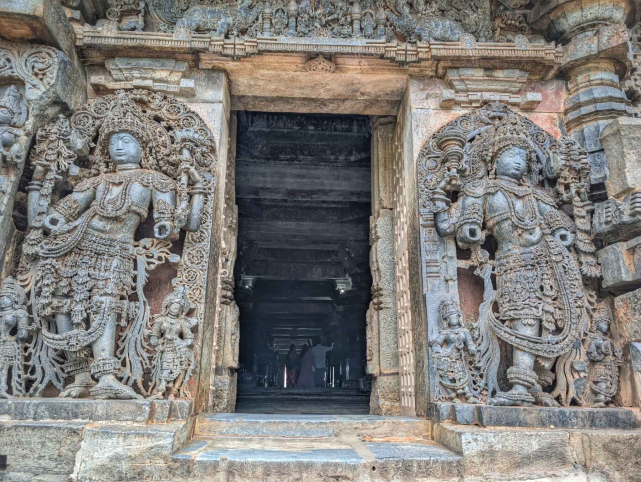 Guardian figure at the entrance of a Hoysala temple, featuring elaborate carvings, dynamic posture, and traditional iconography representing protection and divine vigilance